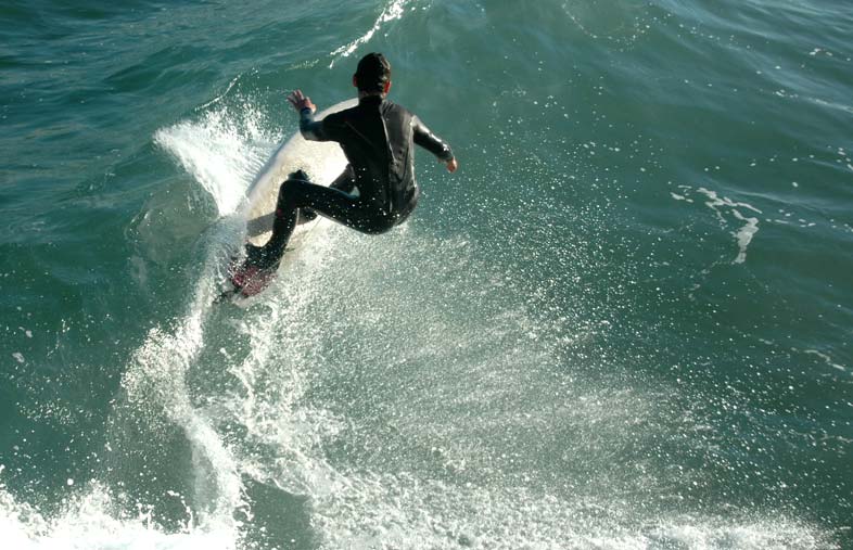 Surfer riding a wave without a surf helmet